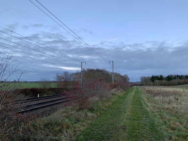 Nous avons quitté la rue de la Mairie et marchons maintenant près de la ligne Mantes-la-Jolie - Cherbourg en direction du bois des Perrois.