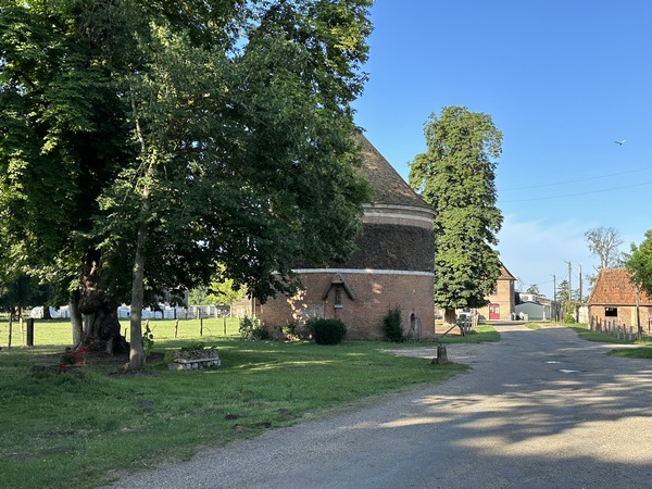 Ancienne forteresse d'un chevalier des comtes d'Evreux, le château des Landes devint, en 1710, une bâtisse de style Louis XIV. Le château a été incendié en 1942, et le comte de Béru assassiné en 1944. On voit ici le colombier et sa statue de Notre-Dame-des-Bois.