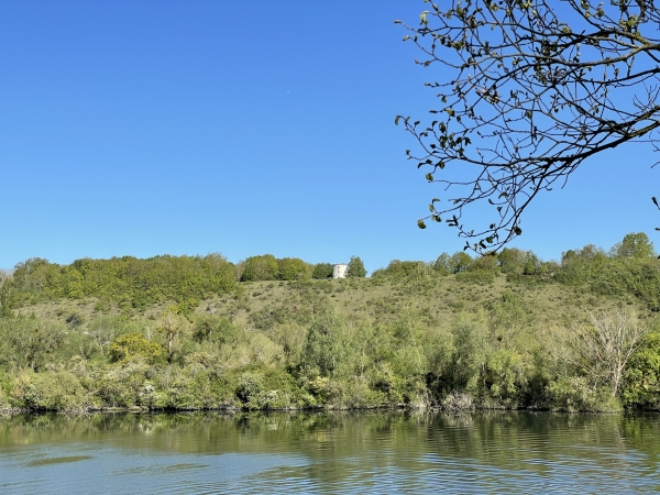 Sur l'autre rive, nous distinguons la Tour de Tosny, souvent confondue avec le moulin de l'Ermitage. La Tour de Tosny est un ancien moulin du XVIe siècle, qui a servi de tour de télégraphe au XIXe siècle, avant de tomber en ruine. Elle a été restaurée en 1984 par des bénévoles