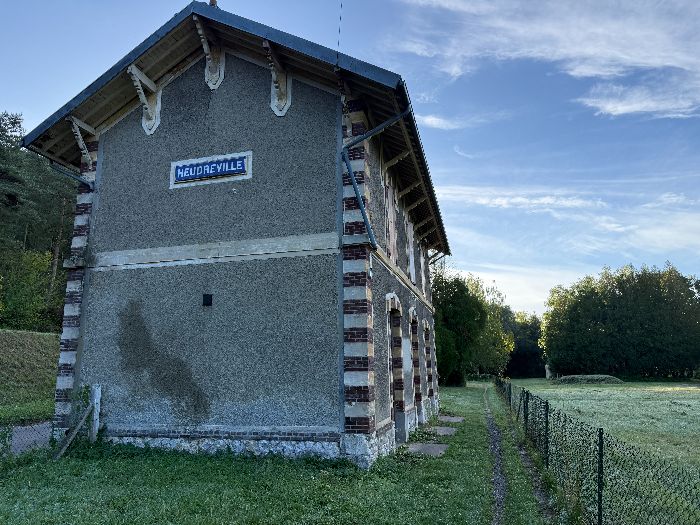 Ancienne gare d'Heudreville. Le chemin passe entre la clôture et l'ancienne gare.
