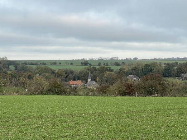 Dans la coulée boisée que forme la vallée de la Saâne, nous voyons la flèche de l'église Saint-Rémy du hameau de Gourel.