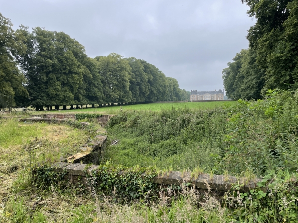 Derrière le saut-de-loup, on distingue le château de Bosmelet de style Louis XIII, restauré après son bombardement pendant la guerre.