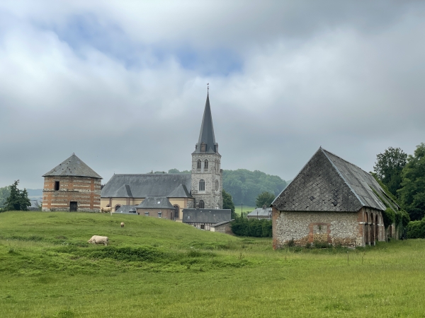 A notre gauche, le colombier et l'église Notre-Dame-de-l'Assomption de Grainville-la-Teinturière. Dans le choeur de l'église est enterré le navigateur Jean de Béthencourt, roi des îles de Canaries.