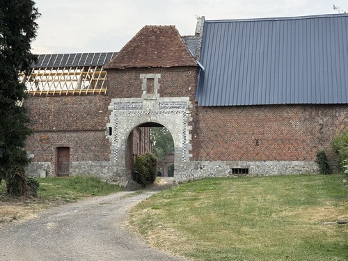 Depuis le parking de l'église, nous longeons cette belle entrée de ferme. Au centre, les armoiries semblent représenter deux licornes qui tiennent un écusson surmonté d'un heaume.