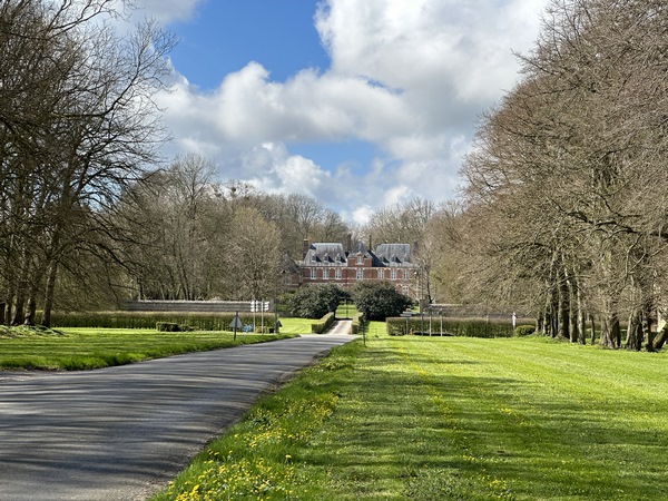 Nous marchons maintenant sur la pelouse de la large avenue qui s'ouvre devant le château d'Ouville&nbsp;(XVIIe) de style Louis XIII en brique et pierre.