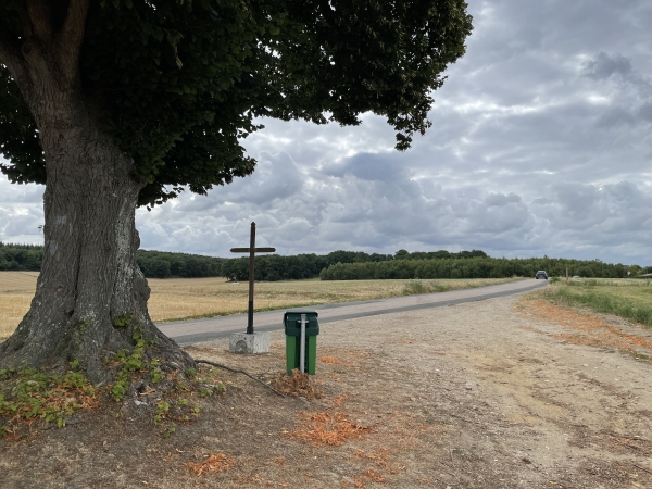 Le chemin débouche au calvaire sur la route de Venables. Nous allons continuer en face sur un chemin caché par l'arbre.