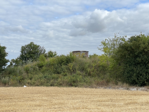 En bordure de chemin, on peut remarquer ce tumulus coiffé d'une cheminée. Cette cheminée, et sa jumelle à l'entrée de Villers sont là depuis 1840. Ce sont deux cheminées d'aération du tunnel du Roule de la ligne Paris-Le Havre. Les trains passent sous nos pieds !