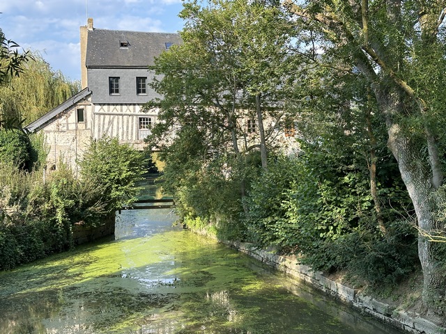 Et voici le Moulin de Muids, ancien moulin à eau du XVIIe siècle. Il repose sur deux murs de pierre et enjambe le Bras du Moulin. Un mécanisme permettait d'ajuster la hauteur de la roue. L'appentis à gauche abrite un moteur à vapeur du XIXe, toujours présent, chargé de suppléer le courant.