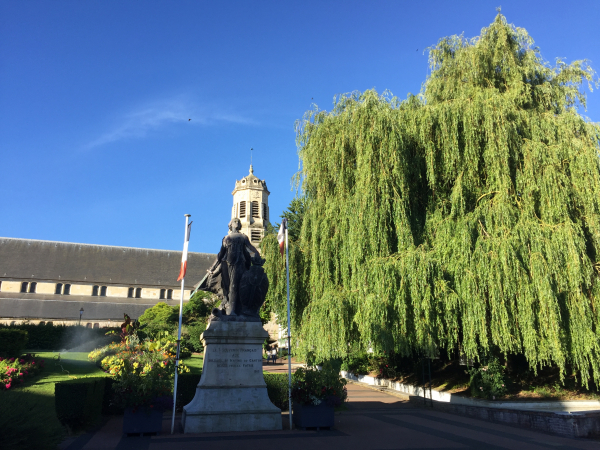 L'église Saint-Léonard, reconstruite aux XVIIe et XVIIIe siècles, et devant nous, le monument aux morts, dans un parc en pente douce.