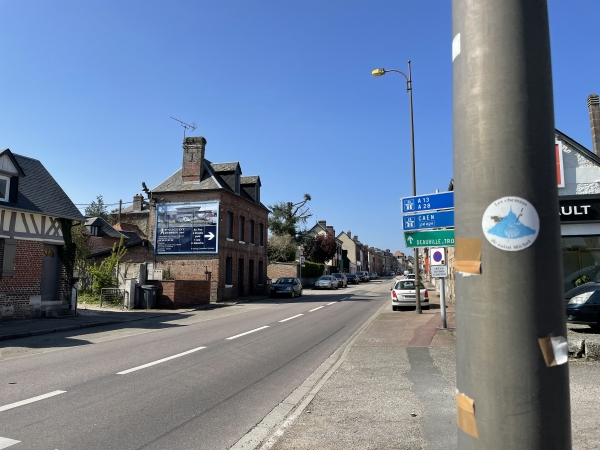 Nous entrons dans Bourg-Achard. La balise, à droite, nous confirme que nous sommes toujours sur les Chemins Normands du Mont-Saint-Michel.