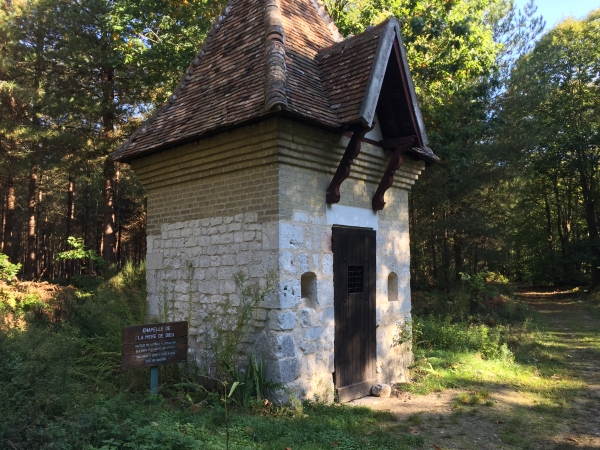 La petite chapelle de la Mère de Dieu, avec ses murs en calcaire et moellon, son toit en pavillon couvert de tuiles.