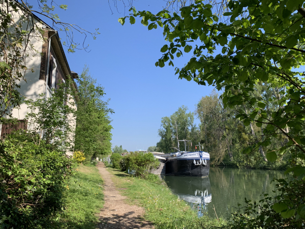 Chemin du Halage le long d'un bras de la Seine en face de l'Île du Trait. La péniche devant nous est une habitation.