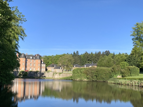 Le château de Couterne (XVIe et XVIIe) derrière son étang.