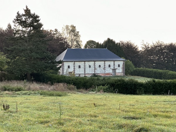 Toujours aux Epinais, le manoir de la Hennière se cache derrière ses arbres et ne laisse voir que cette dépendance.
