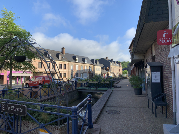 Regard arrière sur la Clérette qui coule devant les commerces de la rue principale de Clères.