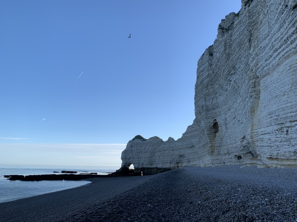 Nous marchons en direction de la Porte d'Amont. Il y a très longtemps, un cours d'eau a creusé les célèbres arches d'Etretat. L'amont de ce cours d'eau était au nord, l'aval au sud, d'où le nom des falaises.