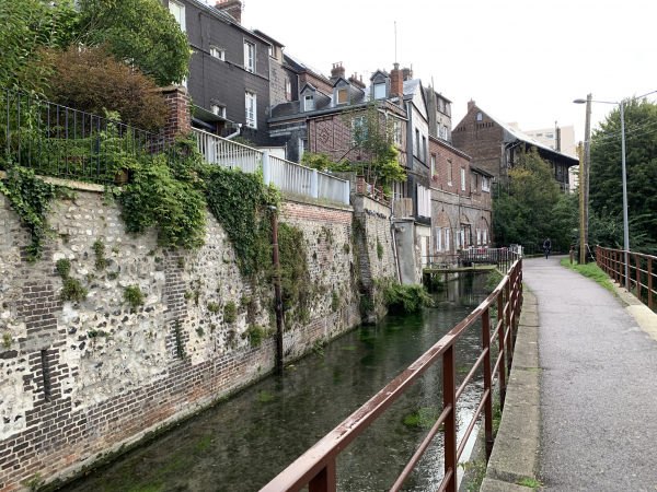 Le Robec coule entre les maisons du quartier Saint-Hilaire et la rue des Petites Eaux de Robec.