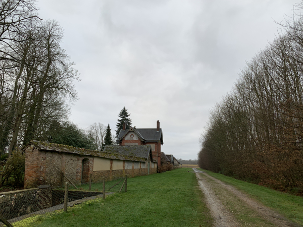 Nous suivons le chemin qui monte directement au château de la Croix-Mesnil, dont nous longeons ici le mur et la maison du gardien.