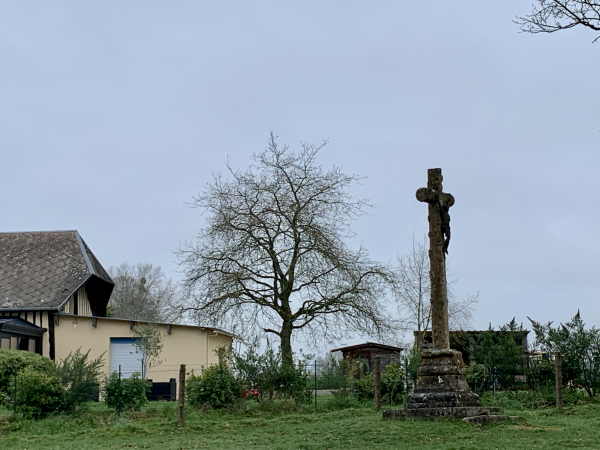 Calvaire de la Côte à Etalleville. Curieusement, le calvaire tourne le dos à la route au bord de laquelle il est implanté. La route passe entre le calvaire et la maison. Le calvaire tourne le dos aux habitants du hameau et aux passants : il est tourné vers le château.