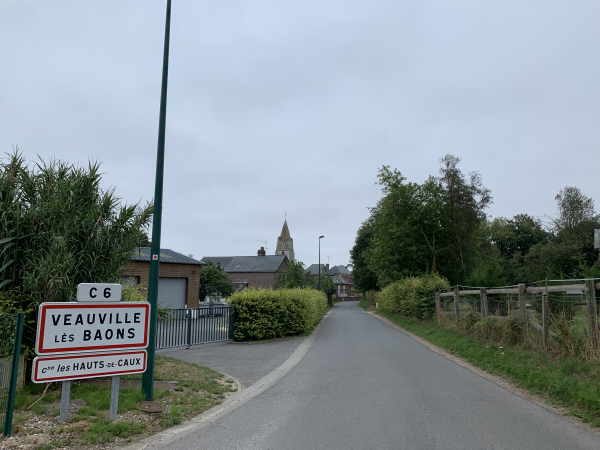 Nous entrons dans Veauville-les-Baons par la C6. On distingue l'église Sainte-Austreberthe (XIXe) et sa flèche de pierres.