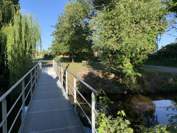 Nous traversons le canal de St-Aubin sur cette passerelle. Ce canal était l'un des ouvrages bâtis au XVIIe siècle pour drainer le Marais Vernier. Après la révolution, faute d'entretien des canaux, les conditions d'hygiène dans les marais se dégradent. Il faut attendre 1886 pour réaménager les canaux.