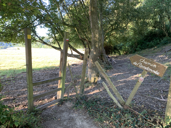 Le GR210 passe dans une prairie équipée de passe-clôtures. A droite, sur le poteau, quelqu'un a accroché une coquille. Nous en verrons plusieurs sur cette étape.