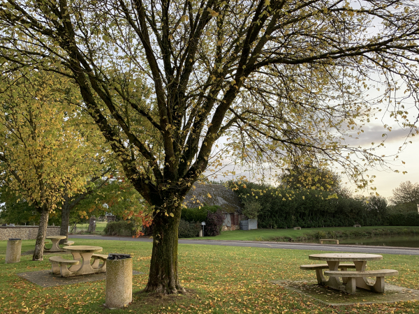 Près de l'église Saint-Pierre se trouve une charmante aire de pique-nique à proximité d'une mare qu'on distingue en arrière plan de la photo.