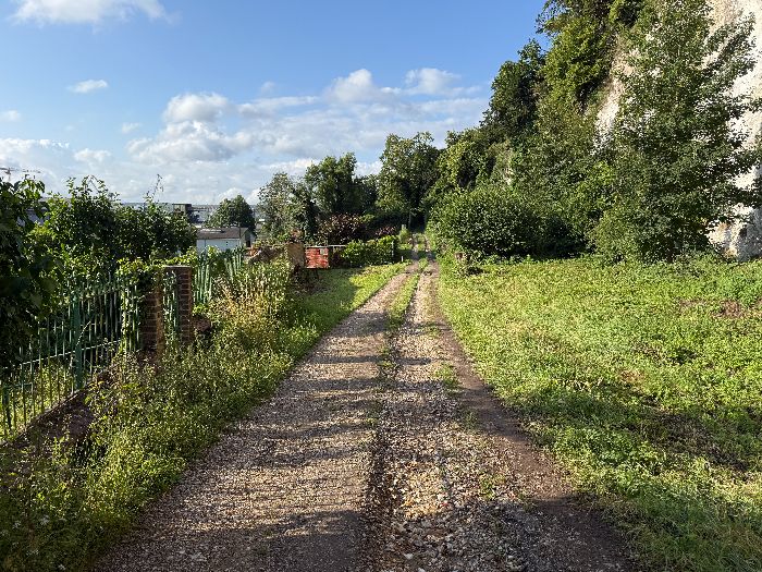 Je tourne à gauche à la première fourche pour rejoindre la délicieuse rue des Champs. Elle porte un nom de rue, mais c'est un chemin qui longe la falaise, et avance en balcon au-dessus de la Vallée.