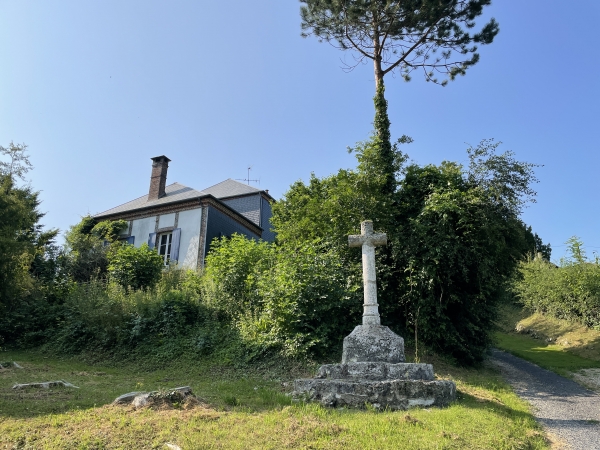 Regard arrière sur le chemin qui descend devant l'église et son calvaire, en direction du parking.