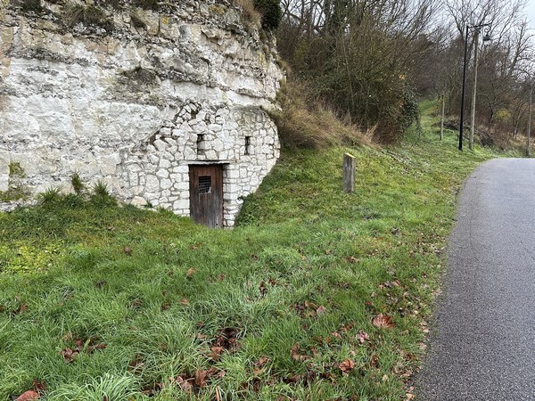 Exemple d'ancienne habitation troglodytique aménagée dans une carrière de craie. Nous allons suivre le chemin dont on devine l'entrée à gauche.