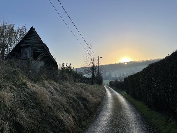 Nous quittons la rue Saint-Ouen (D62) où nous sommes garés, et suivons la petite route du Pont Léon pour rejoindre l'Andelle. Le soleil se lève au-dessus de la forêt de Lyons.
