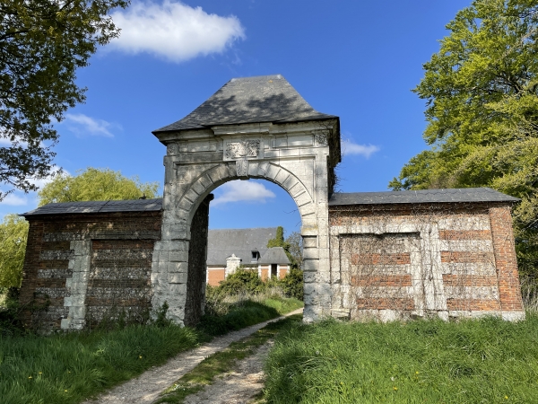 La porte en pierre de taille, date du premier château (XVIe). Elle présente les armoiries d'Isaac de Lintot et Françoise de Thiboutot. Derrière, le logis en brique et pierre semble bien abîmé sur la droite. Le toit est percé et le pignon est couvert de végétation...