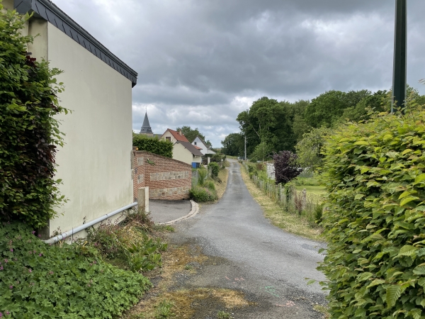 Le chemin traverse le village et débouche non loin de l'église dont on aperçoit la flèche.