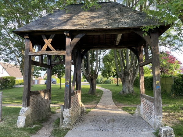 On accédait au manoir Dorival par un grand portail charpenté couvert fermé de deux portes de tailles différentes. Ce portail, dont les portes ont aujourd'hui disparu, permettait de franchir le mur de bauge qui entourait la propriété. Ce type de dispositif est typique de la campagne du Neubourg (Wikipedia). Nous tournons à gauche.