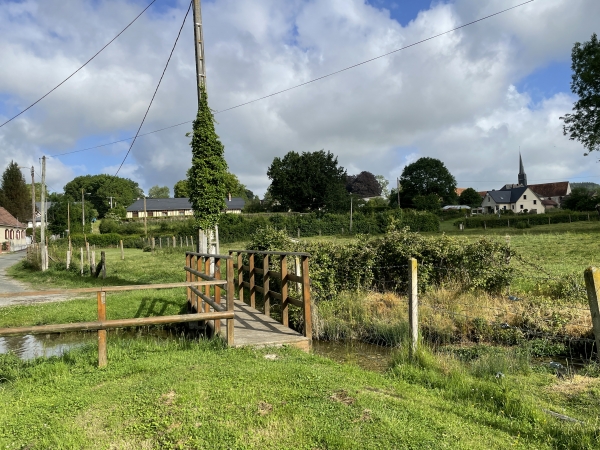 Une passerelle enjambe le fossé qui canalise les eaux de la source vers la Béthune.