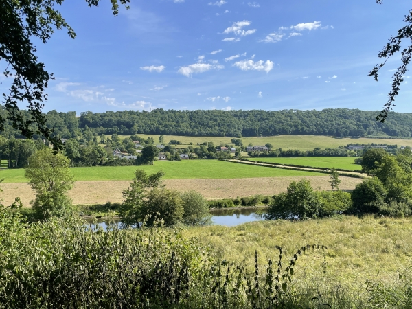 Des trouées dans les haies permettent de voir l'Orne, et ici, sur l'autre rive, le hameau aux Bins.