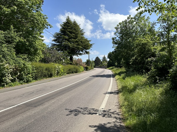 Finalement, les quelques dizaines de mètres à faire sur la Route Neuve ne sont pas périlleux : l'accotement herbeux permet de marcher à l'écart des voitures. Il y a même un trottoir de l'autre côté.
