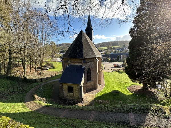 Vue sur l'église et sur un captage de source du Robec depuis le chemin qui monte en forêt.