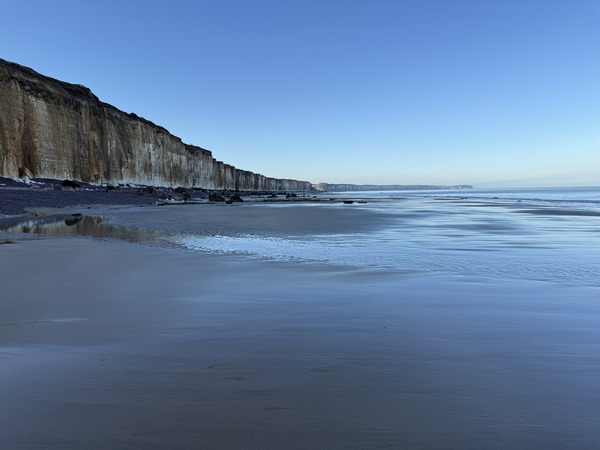 Je marche sur la plage de sable ferme en direction de Veules-les-Roses. C'est la basse mer, je peux marcher à bonne distance des falaises.