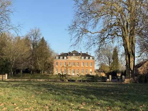 Sur notre droite on peut voir, au-dessus d'une haie, le château de Bois-Guilbert, célèbre pour son jardin des sculptures de Jean-Marc de Pas.