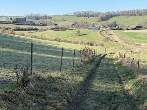 Nous quittons les routes et les rues pour descendre dans la vallée de l'Héronchelle (ou Héron). On distingue à gauche l'église Saint-Denis de Rebets.