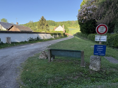 La Sente des Meuniers quitte le bourg et monte sur le coteau ouest. Les balises sur la pancarte sont celles du GR222 et du circuit des Roches.