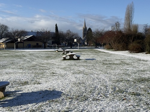 L'Allée du Château longe le stade de Pont-Saint-Pierre (tables de pique-nique). On distingue la flèche de l'église Saint-Nicolas (XIIe XIXe).