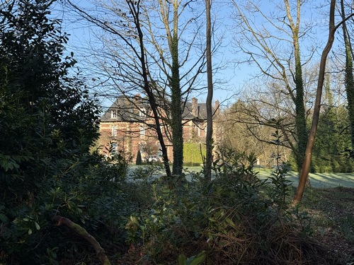 On devine le manoir de Capsart derrière les arbres.