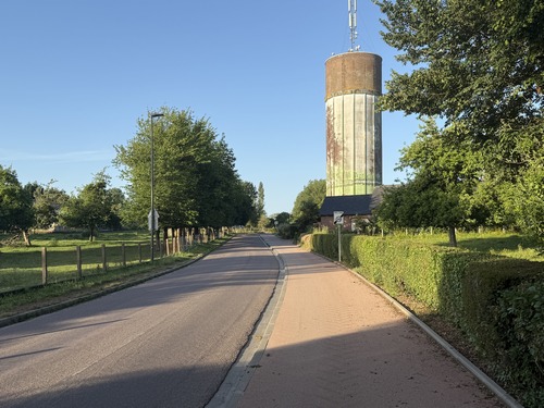 Nous sortons du bourg par la route de Fréville, sur la piste cyclable. Le château d'eau en face est peint d'un paysage bucolique.