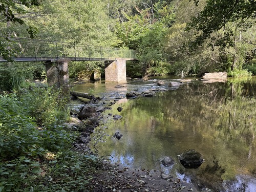 La passerelle de l'ancien moulin traverse l'Orne.