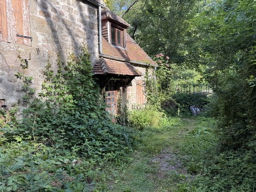 Pour rejoindre la passerelle, il faut longer l'ancien moulin. Il avait été aménagé en habitation, occupée jusqu'à récemment, mais semble désormais lui aussi à l'abandon.