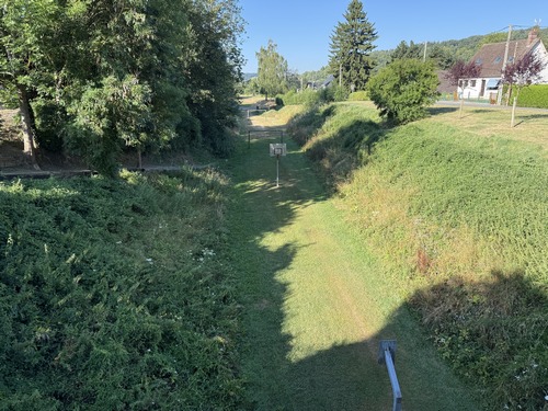 Vue, depuis la passerelle, sur l'ancienne voie ferrée que nous avons suivie pour entrer dans le bourg.